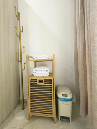 a small wooden shelf next to a trash can at UMRA Homestay in Kampong Padang Kemunting