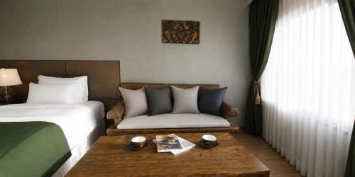 ein Hotelzimmer mit einem Bett und einem Couchtisch in der Unterkunft Login Hotel in Jeju-do