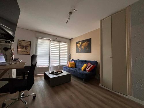 a living room with a blue couch and a table at Studio de vacances Stella Plage in Cucq