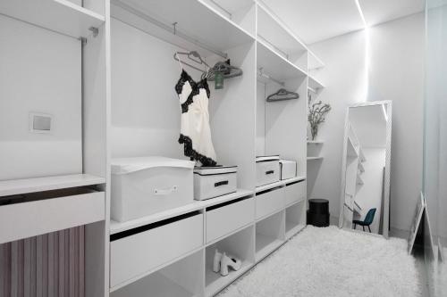 a bathroom with white cabinets and a mirror at Bella Casa - piso inferior in Angra do Heroísmo