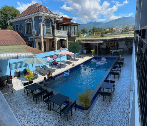 an overhead view of a pool with chairs and umbrellas at Santara Hostel in Vang Vieng