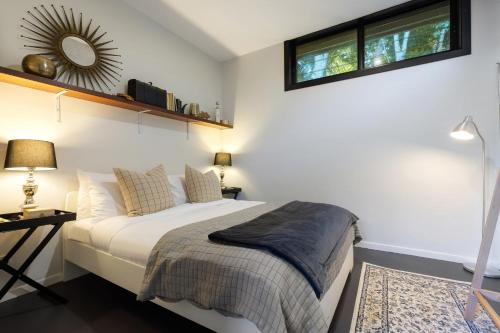 a bedroom with a bed and a mirror on the wall at Glenbrook Guest House in Ewingsdale