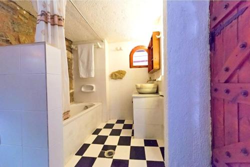 a bathroom with a pink door and a checkered floor at Elounda Monastiri Cretan sea view house with pool in Epáno Eloúnda