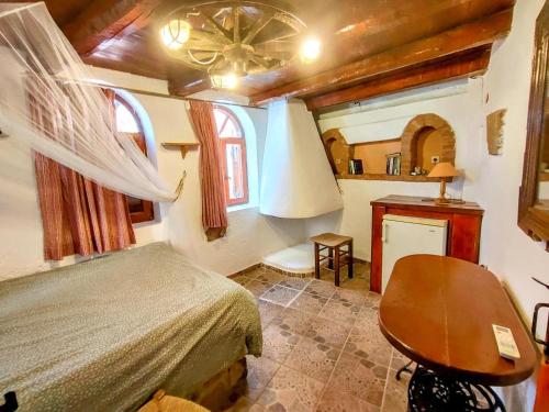 a bedroom with a bed and a chair in a room at Elounda Monastiri Cretan sea view house with pool in Epáno Eloúnda
