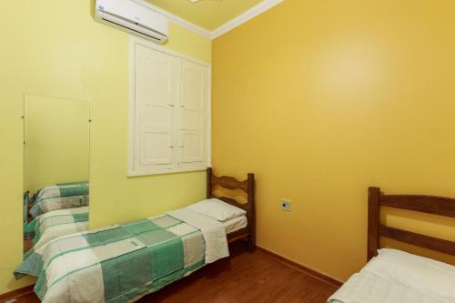 Habitación pequeña con 2 camas y ventana en Hotel Boa Viagem, en Belo Horizonte