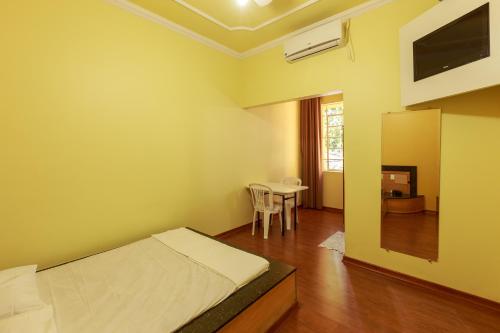 1 dormitorio con 1 cama y 1 mesa con sillas en Hotel Boa Viagem, en Belo Horizonte
