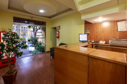 an office with a reception desk and a christmas tree at Hotel Boa Viagem in Belo Horizonte