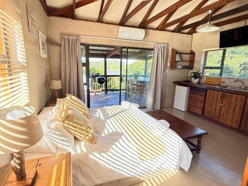 a bedroom with a large bed and a kitchen at East River @ 21 in Kleinemonde