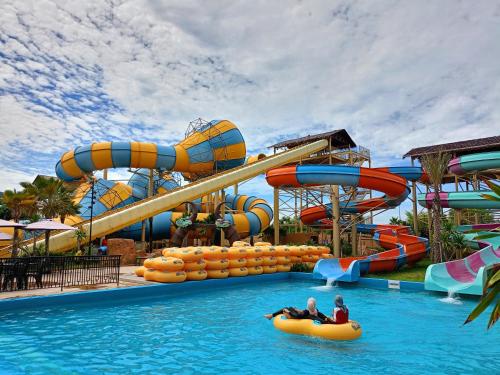 two people riding on an inflatable raft in a water park at Bertam Resort & Water Park Penang in Kepala Batas