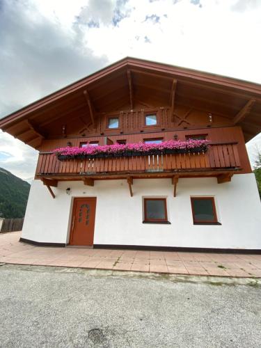 a building with a balcony with flowers on it at Waldboden in San Leonardo in Passiria