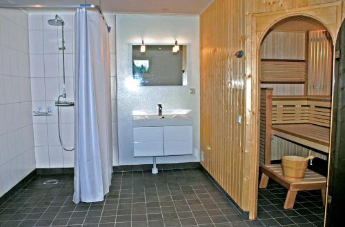 a bathroom with a sink and a shower and a staircase at Villa Vilan - Countryside Lodging in Skillingaryd