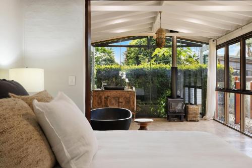 a bedroom with a bed and a tub and a fireplace at Glenbrook House and Studio in Ewingsdale