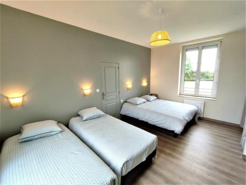 a room with two beds and a window at Gîte G4144 in Saint-Pierre-de-Varengeville