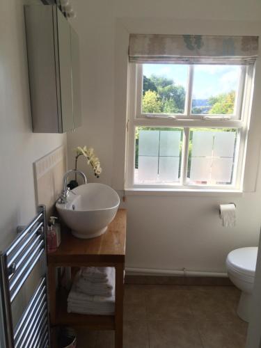 a bathroom with a bowl sink and a window at Hillside Cottage in Wirksworth