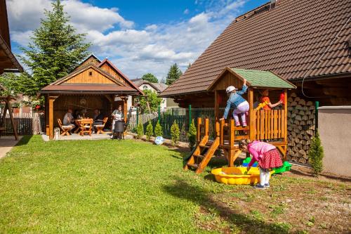 a group of people playing on a playground in a yard at Drevenica Horehronka in Závadka nad Hronom