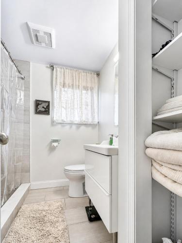 a white bathroom with a sink and a toilet at Elegant Cambridge Room, Short Walk to Harvard in Cambridge