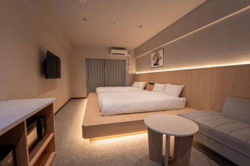 a hotel room with a bed and a couch at The ISA Hotel Tenjin Fukuoka in Fukuoka