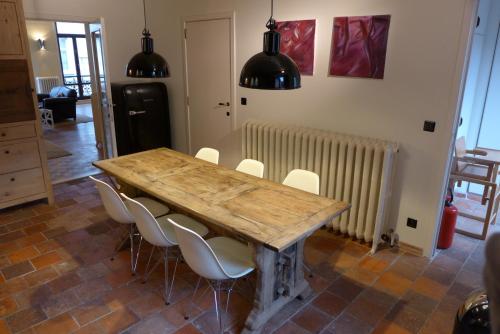 a dining room table with white chairs and a radiator at CitytripGent Apartment in Ghent