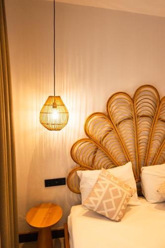 a bedroom with a bed with a wooden headboard and a lamp at Kotraba Alacati Hotel in Alaçatı