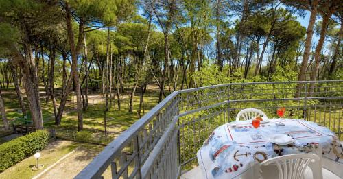 a table and chairs on a balcony with trees at I Velieri in Cesenatico