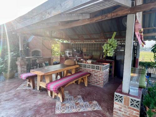 a wooden table and benches on a patio at Driftwood and Jolie cottages in Sam Roi Yot