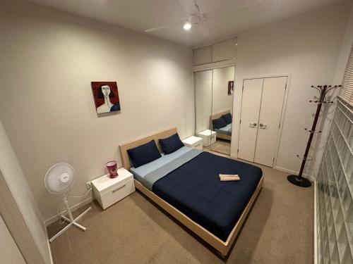 a bedroom with a bed with a blue bedspread at Viaduct Spacious 2 Bedroom Apartment in Auckland