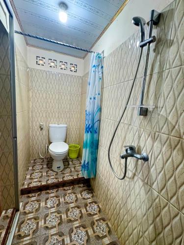 a bathroom with a shower and a toilet at Marlynto Surf Camp in Hilibotodane