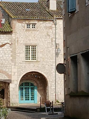 a large stone building with a blue door at au coin perdu in Lauzerte