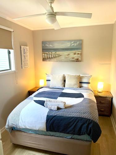 a bedroom with a large bed with a ceiling fan at Pine View Holiday Rental in Emu Bay