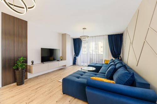a living room with a blue couch and a tv at MoHost Blue Moon Apartments in Braşov