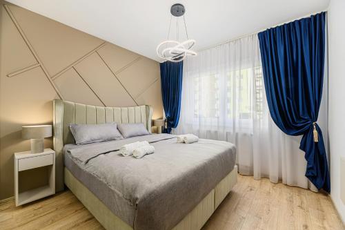 a bedroom with a bed with two towels on it at MoHost Blue Moon Apartments in Braşov