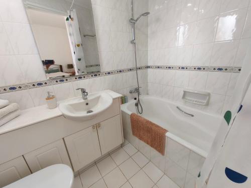 a bathroom with a sink and a tub and a toilet at Eden gardens in Paphos