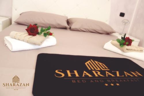 a bed with two towels and a sign on it at Sharazan in Canicattì