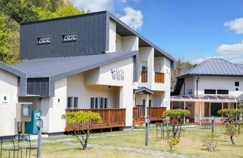 a large white building with a black roof at Samcheok Yonghwa Silkroad Pension in Samcheok