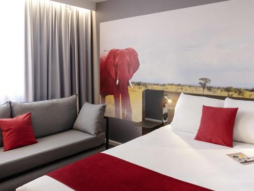 a hotel room with a bed and a couch at Novotel Lyon Gerland in Lyon