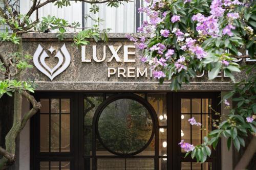 a sign over a door with purple flowers at Luxe Paradise Suites Hotel & Spa in Hanoi