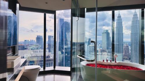 a bathroom with a bath tub in front of a window at Imperial KLCC Residences in Kuala Lumpur