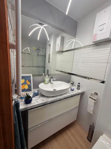 a bathroom with a white sink and a mirror at Zakątek Lechicki Domek in Tarnów Jezierny