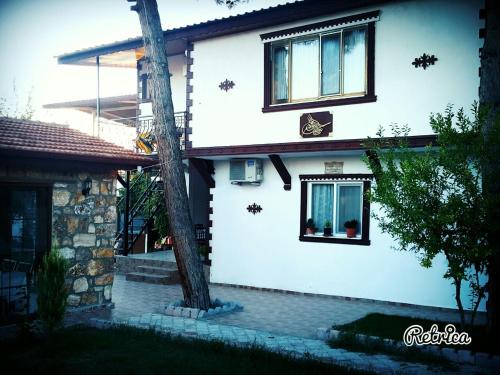 a white house with a tree in front of it at Pınar Vintage House in Pamukkale