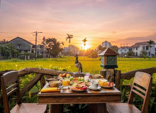 a bird sitting on a table with food on it at Hoi An Chic - Green Retreat in Hoi An