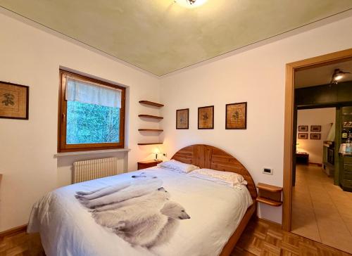 a bedroom with a bed with white sheets and a window at Dolomites Soundscape - Birds River Snow Ski Bus Bike Hike in Alleghe