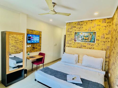a bedroom with a bed and a desk and a tv at Hotel Diamond View in Greater Noida