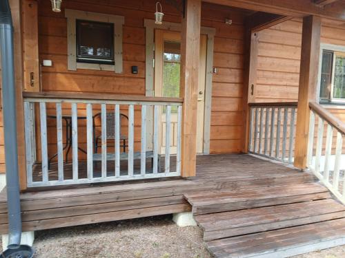a front porch of a wooden cabin with a tv at Villa Polly, Jaala, Luxury cottage with private sauna in Kouvola