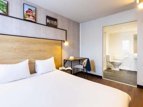 a hotel room with a bed and a bathroom at ibis Epinal Centre in Épinal