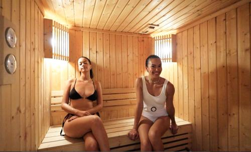 two women are sitting in a sauna at Maraleina Sports Resort in Nathon Bay
