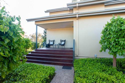 a porch of a house with two chairs on it at The Gums - Echuca Holiday Homes in Echuca
