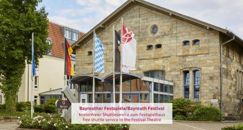 a building with flags in front of it at H4 Hotel Residenzschloss Bayreuth in Bayreuth