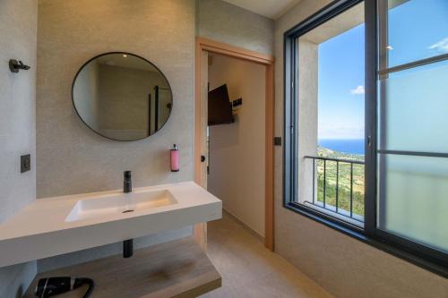 a bathroom with a sink and a mirror and a window at Le Belvedere in Lavatoggio