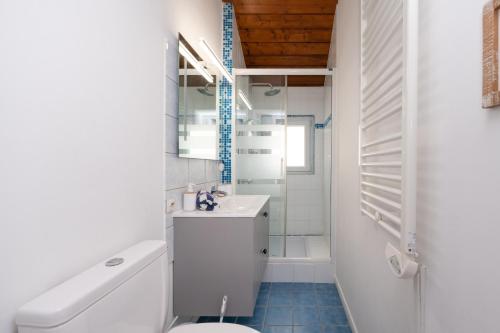 a white bathroom with a sink and a toilet at La Proue , duplex face mer in Arzon