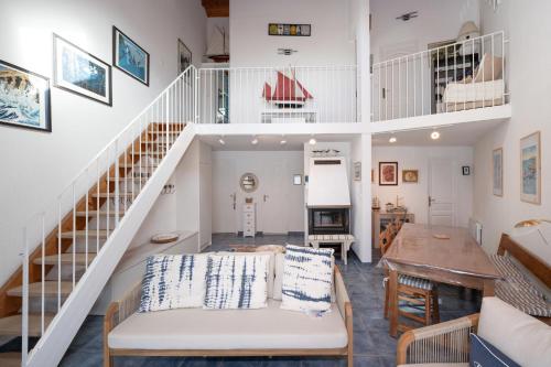 a living room with a staircase and a table at La Proue , duplex face mer in Arzon